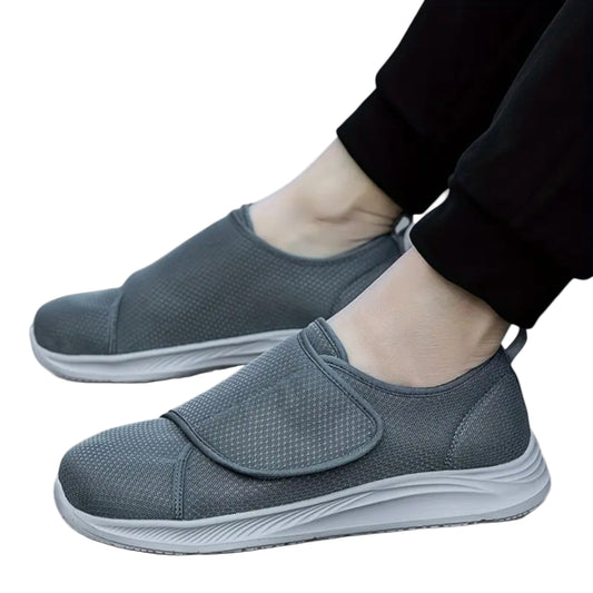 Gray slip-on shoes worn with black pants on a white background